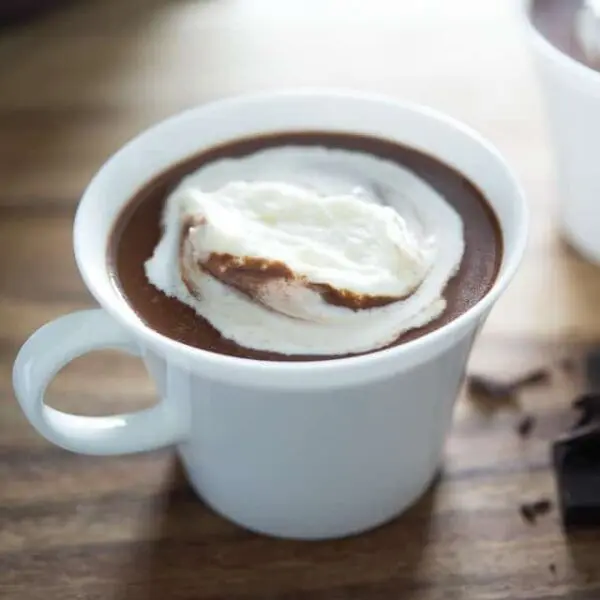 A cup of hot chocolate with whipped cream on top.