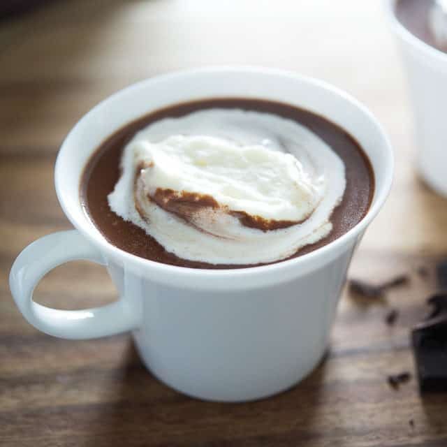 A cup of hot chocolate with whipped cream on top.