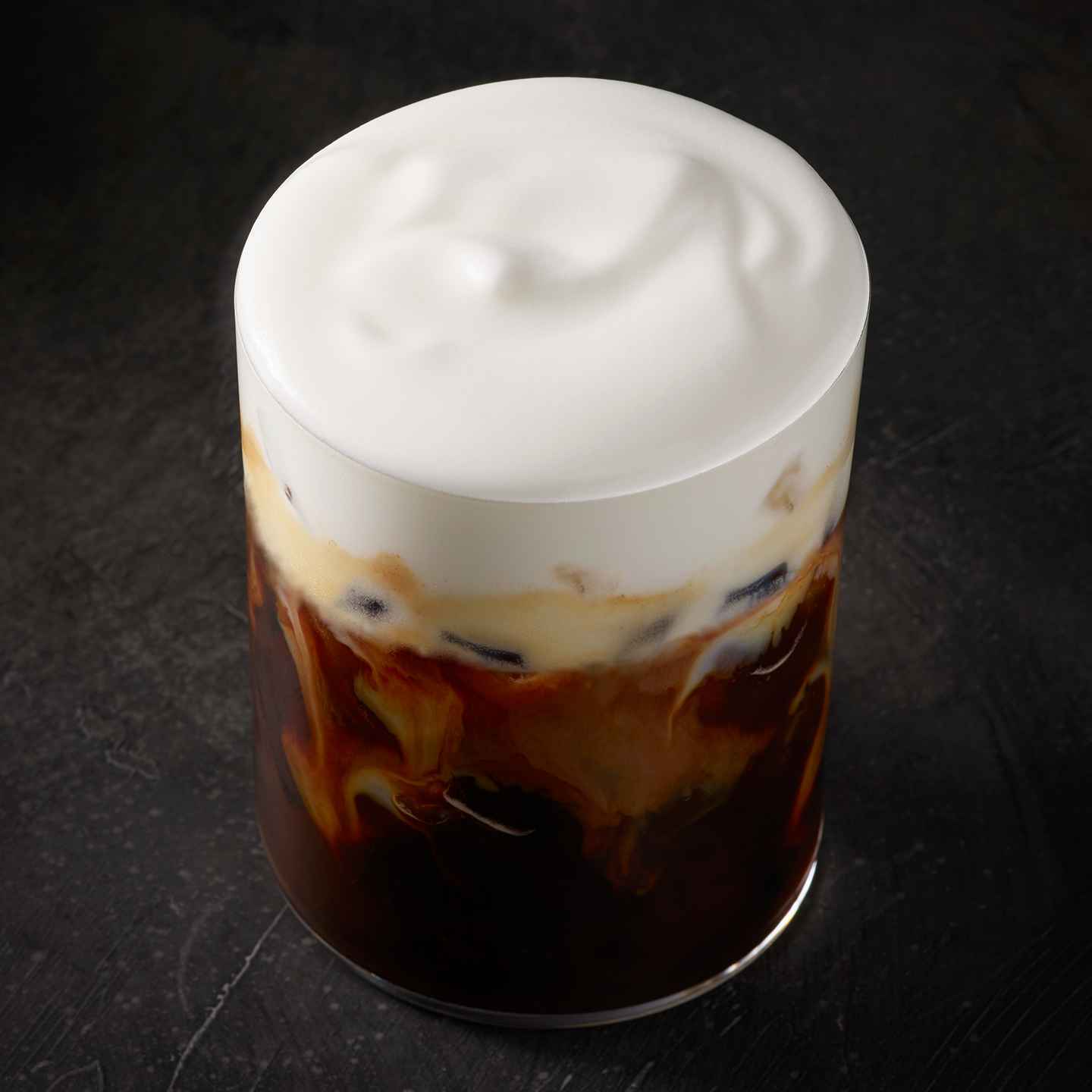A cup of coffee with whipped cream on top.