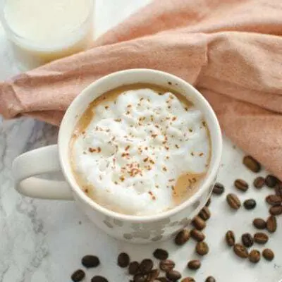 A cup of coffee with cream and cinnamon on top.