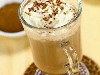 A cup of coffee with whipped cream on top.