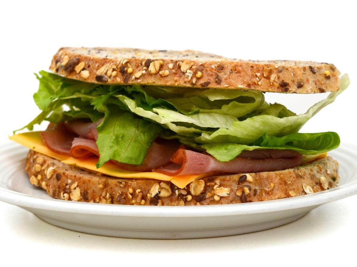 A sandwich on a plate with lettuce and tomato.