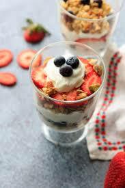 A glass of yogurt and berries in a cup.