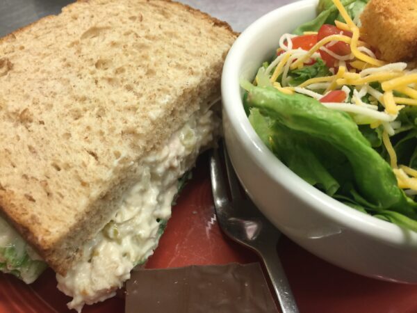A sandwich and salad are on the table.