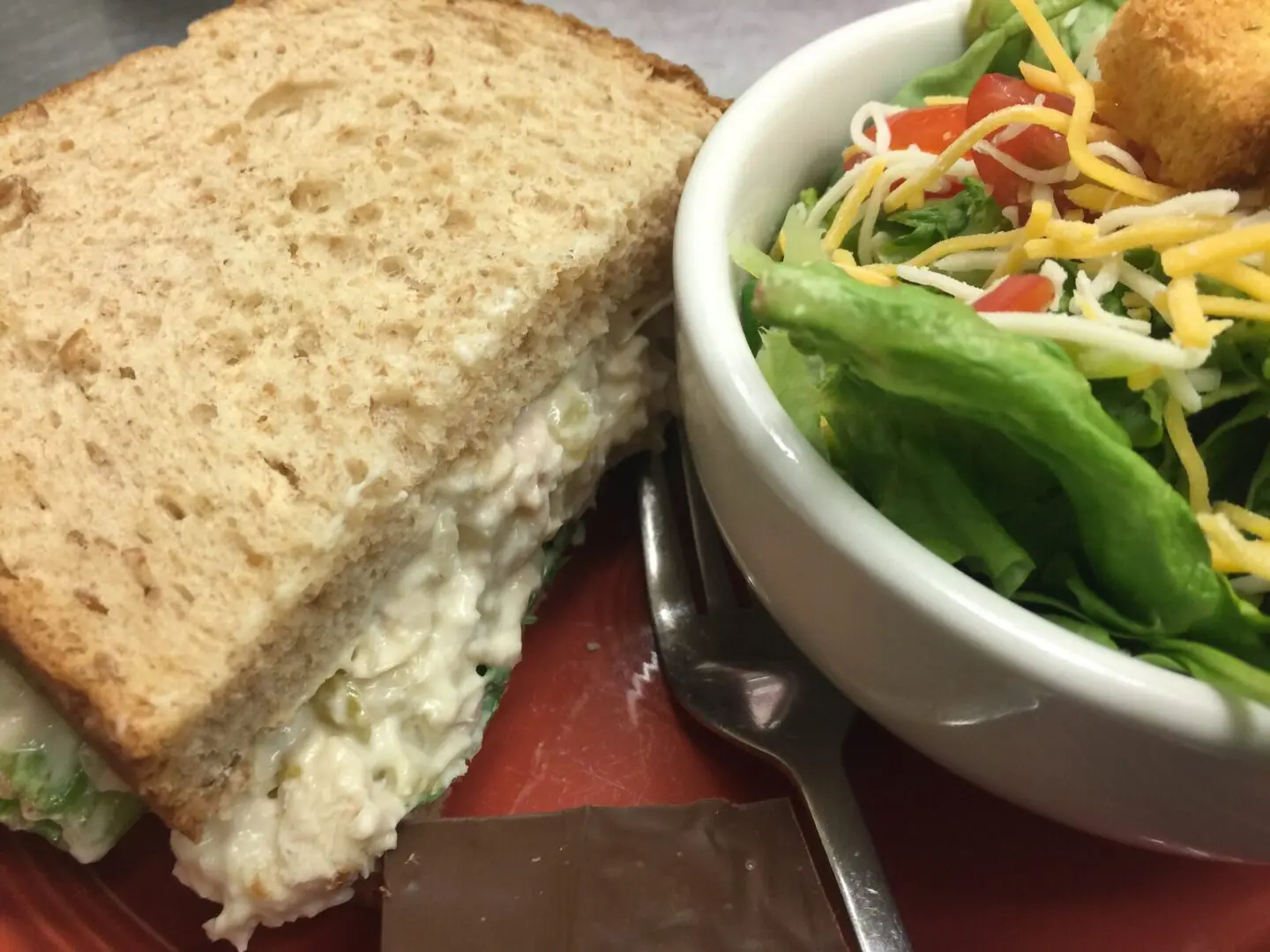 A sandwich and salad are on the table.