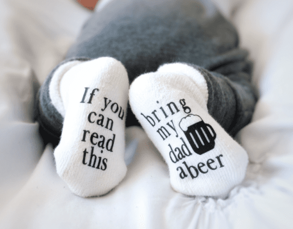 A person wearing socks with beer written on them.