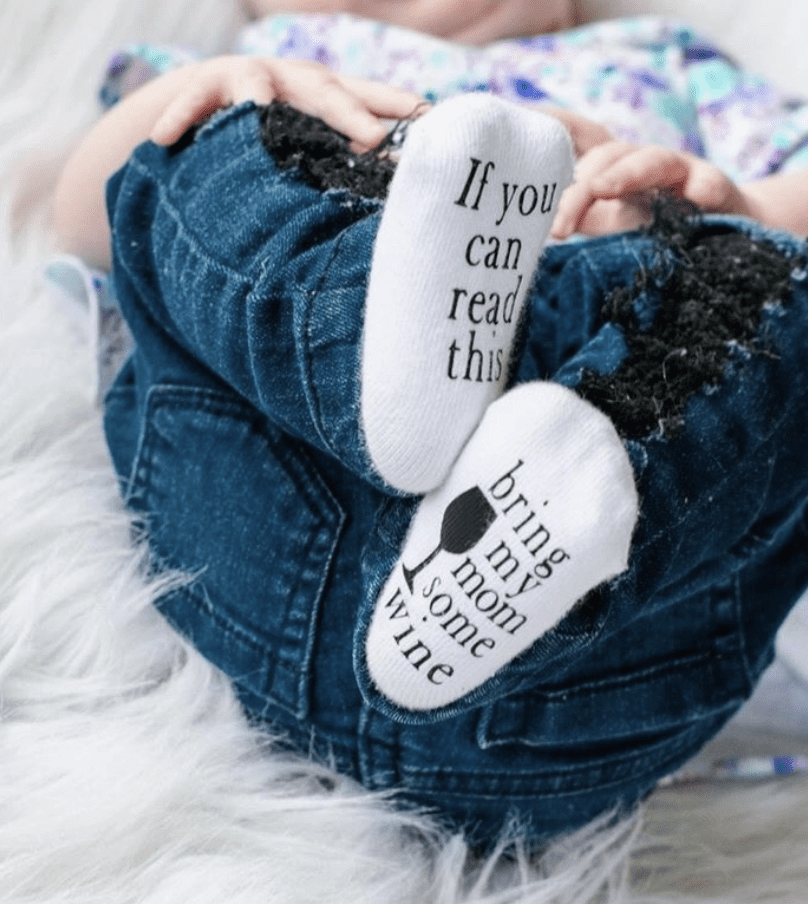 A person wearing jeans and slippers with words on them.