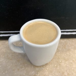 A cup of coffee sitting on top of a table.
