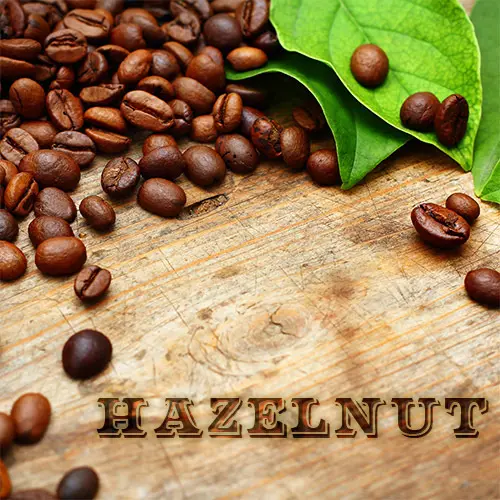 A wooden table topped with coffee beans next to leaves.