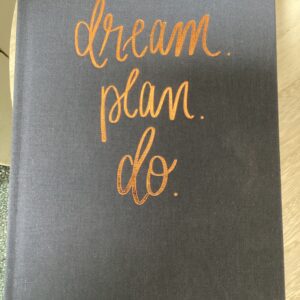 A notebook with the words " dream plan do ".