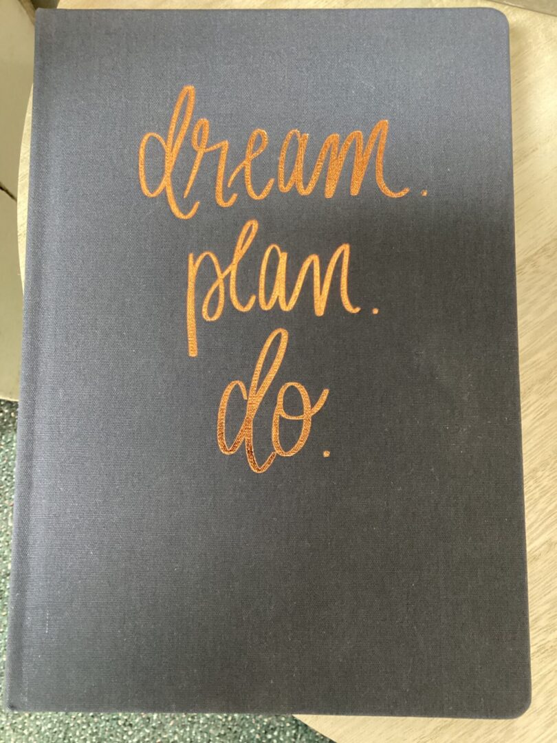 A notebook with the words " dream plan do ".