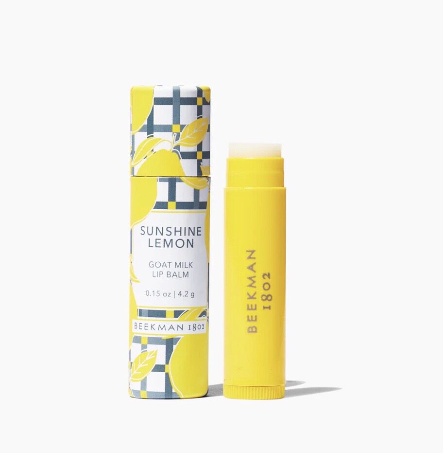 A tube of lip balm next to it in its packaging.