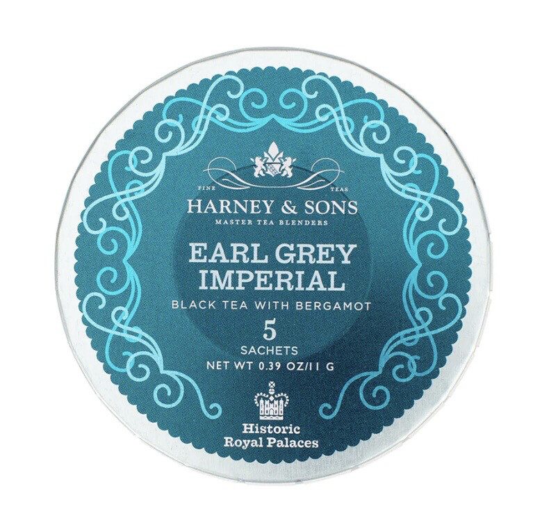 The Harney & Sons Earl Grey Imperial Tea comes in round packaging adorned with a teal design, and it includes text stating that it contains 5 black tea sachets infused with bergamot, with a net weight of 0.39 oz (11 g).