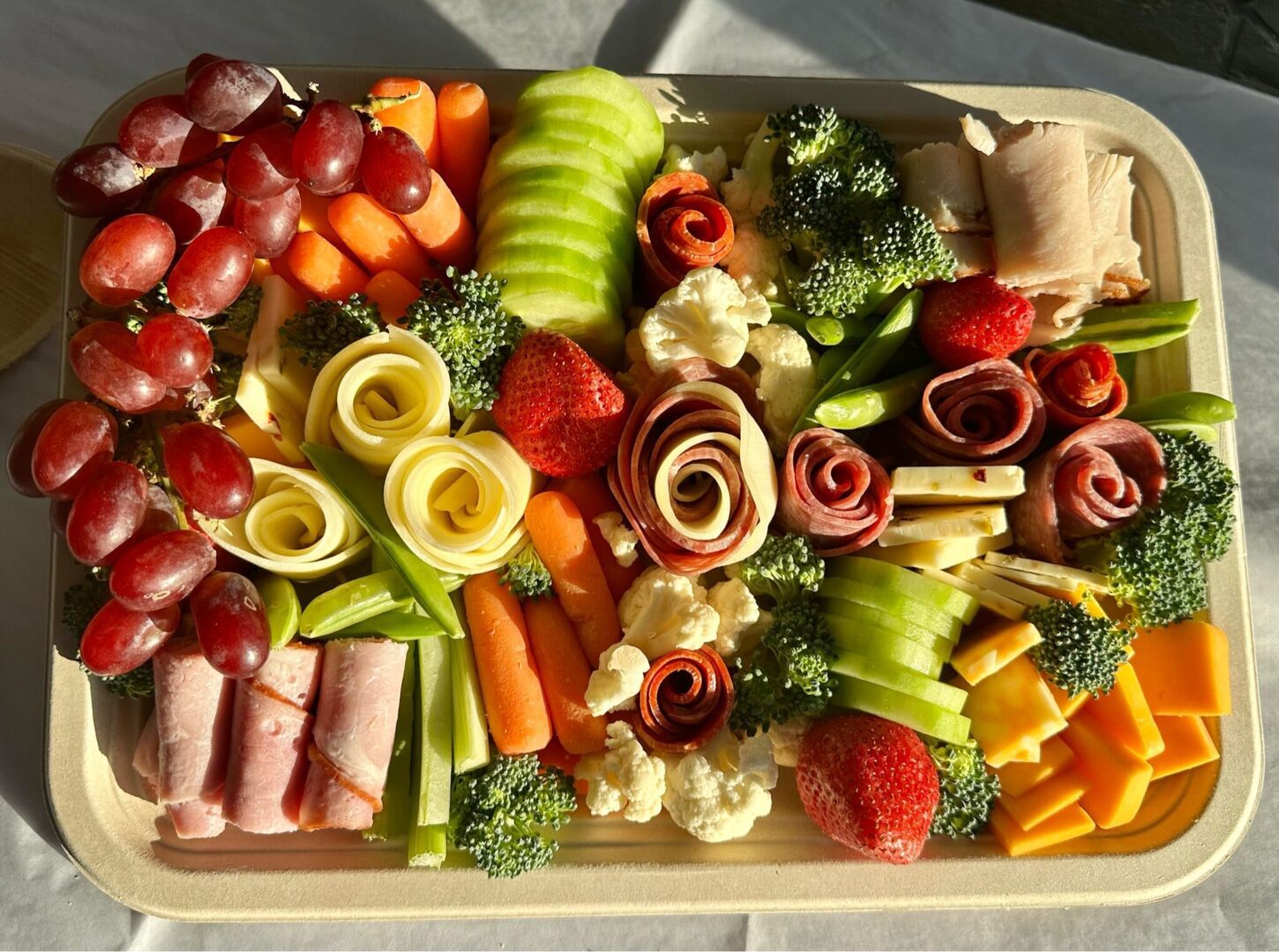 A tray of food with various vegetables and meats.