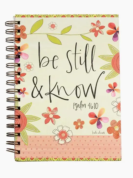 A spiral bound notebook with the words " be still and know."