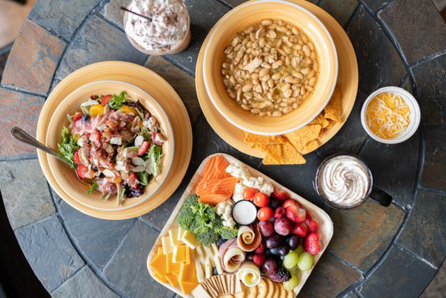 A table with bowls of food and plates on it