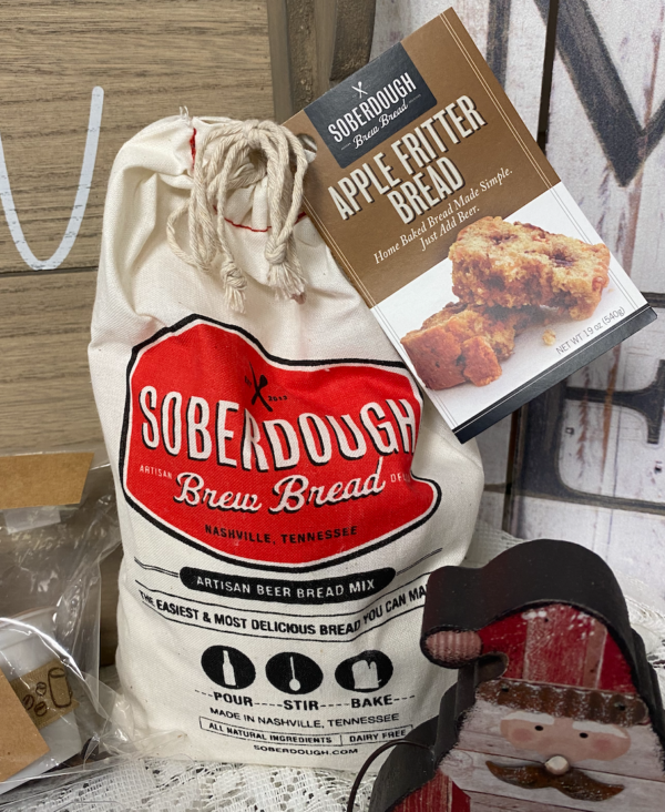 Sack of Soberdough Brew Bread Mix with a box of Apple Fritter Bread mix beside it, displayed on a wooden surface.