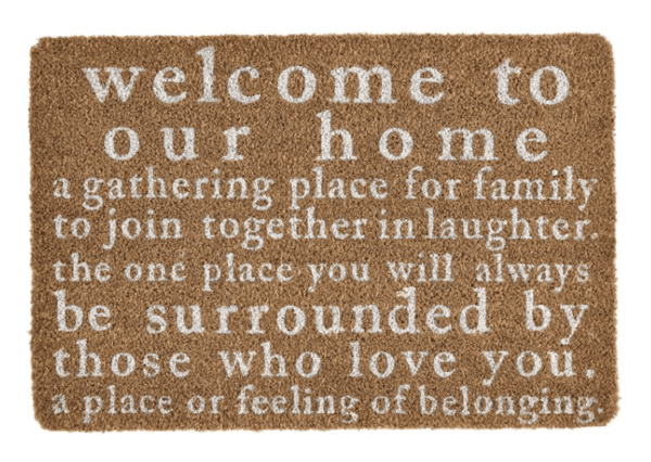 A doormat with the text: "Welcome to our home, a gathering place for family to join together in laughter. The one place you will always be surrounded by those who love you. A place of belonging.