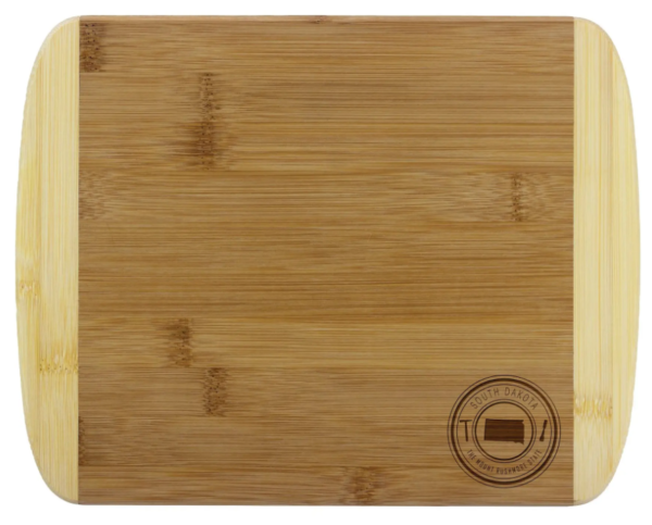A rectangular bamboo cutting board with a South Dakota emblem in the lower right corner.