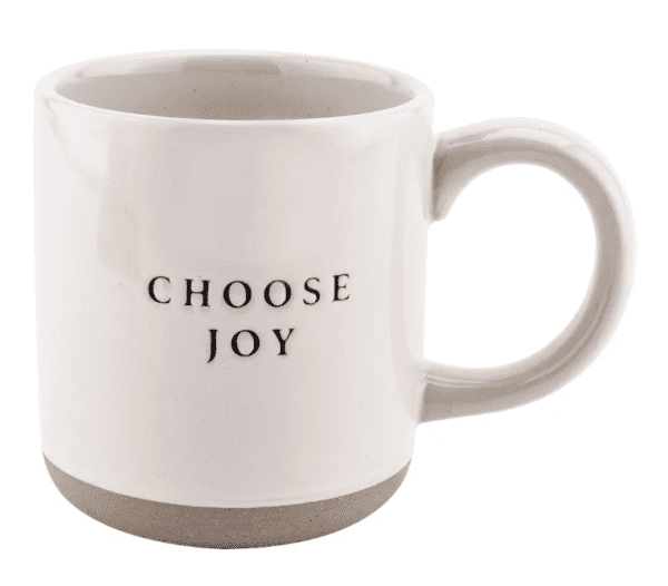 A white ceramic mug with "CHOOSE JOY" written in black text on one side.