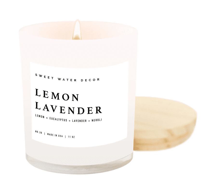 White candle in a glass jar with a wooden lid, labeled "Lemon Lavender." The label also lists lemon, eucalyptus, lavender, and neroli. The candle is lit.