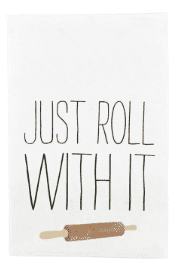 A white kitchen towel with the phrase "JUST ROLL WITH IT" and an illustration of a rolling pin.