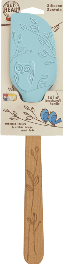 A silicone spatula with an embossed owl and branch design, attached to a beechwood handle with a similar etched pattern. Packaging features illustrations and product details.