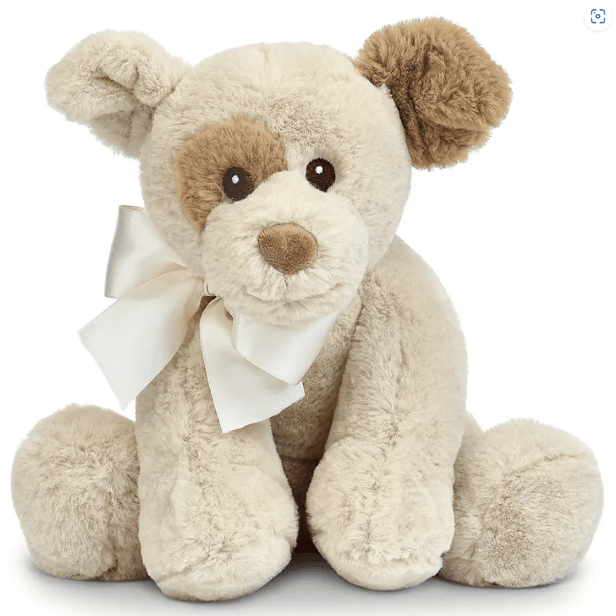 A beige plush teddy bear with a white ribbon around its neck, featuring light brown patches around one eye and ear, sitting upright.