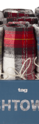 Folded plaid towels in a box labeled "tag.