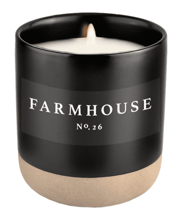 Black candle labeled "Farmhouse No. 26" with a light-colored base.
