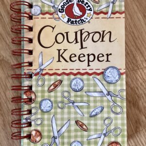 Coupon keeper notebook with scissors and coins.