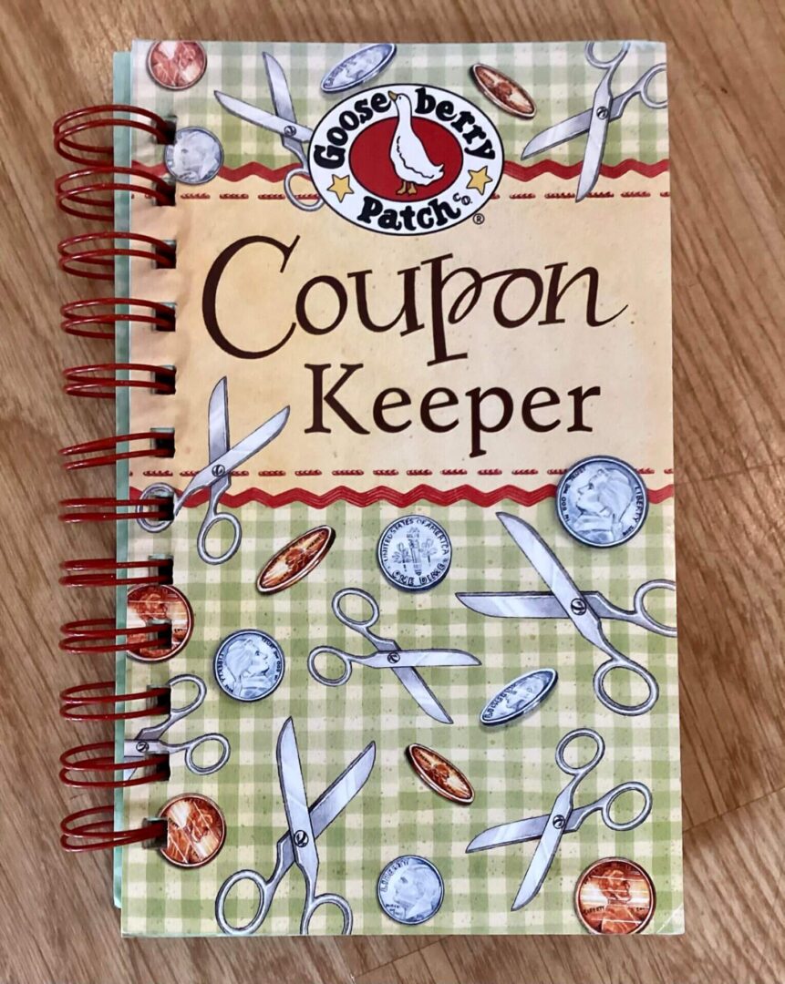 Coupon keeper notebook with scissors and coins.