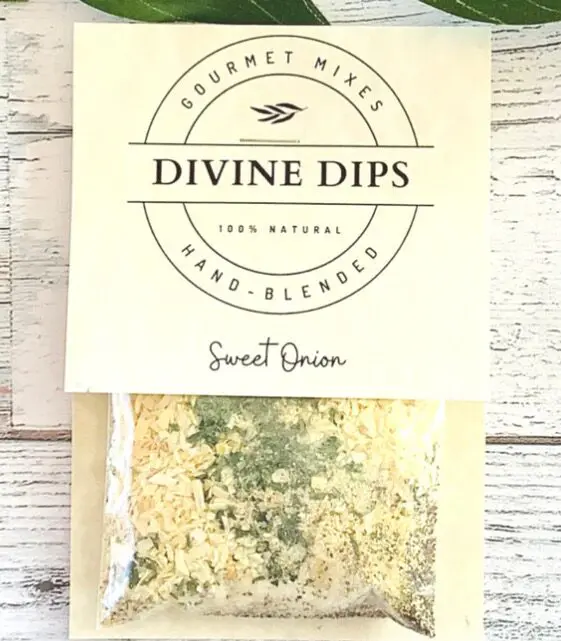 Packaging of Divine Dips Sweet Onion, 100% natural gourmet hand-blended mix, shown on a white wooden surface.