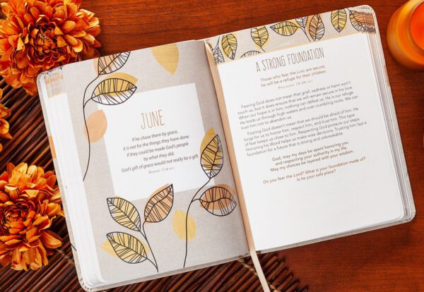 Open the For I Know The Plans (6x8 - Faux Leather Devotional) to the "June" page, which features a quote and decorative leaves. Candles and flowers are arranged beside it on a wooden surface.