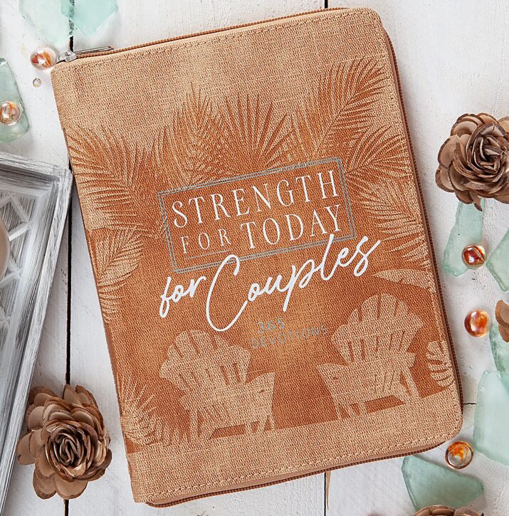 A tan book titled "Strength for Today for Couples" is surrounded by decorative flowers and glass pieces, featuring printed palm trees and chairs on its cover.