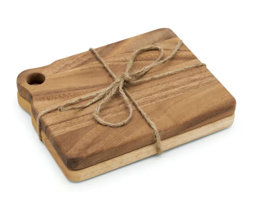 A wooden cutting board with rounded edges, tied with a simple twine into a bow.