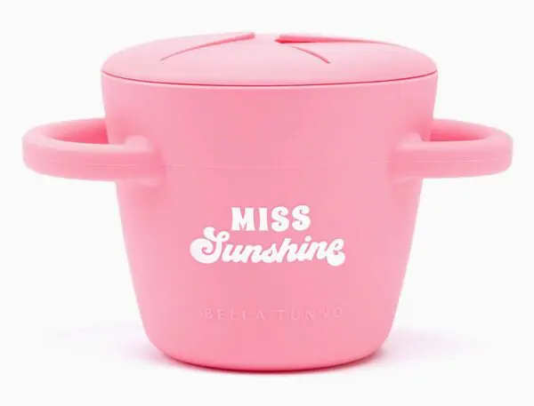 Pink silicone snack cup with handles, labeled "Miss Sunshine" and "Bella Tunno" on the front.