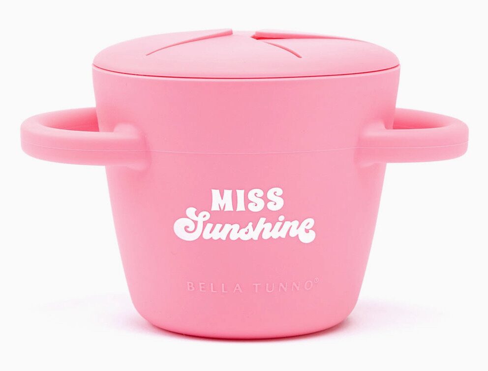 Pink silicone snack cup with handles, labeled "Miss Sunshine" and "Bella Tunno" on the front.