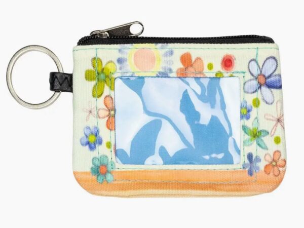 The Change The World ID Wallet is a compact coin pouch with a keyring, showcasing a floral design and a transparent ID slot on one side.