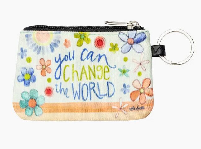 A coin pouch with floral designs and the phrase "You can change the world." It has a zipper and a metal keyring attached.