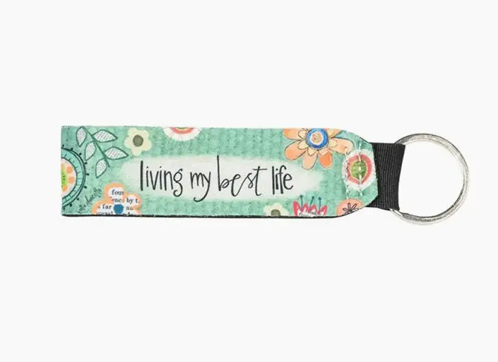Keychain with a floral design and the text "living my best life" printed on it.