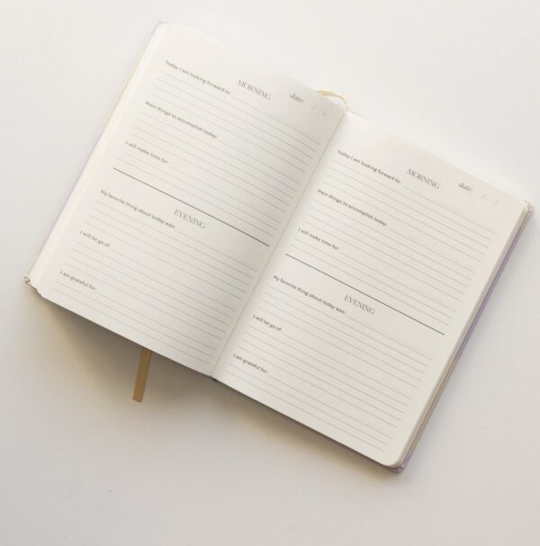Discover the Be Mindful Fabric Journal, designed with "Morning" and "Evening" sections for daily reflections and gratitude, offering lined prompts visible on each page.