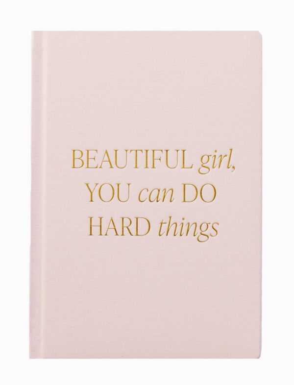 A beige notebook with gold text saying, "Beautiful girl, you can do hard things.