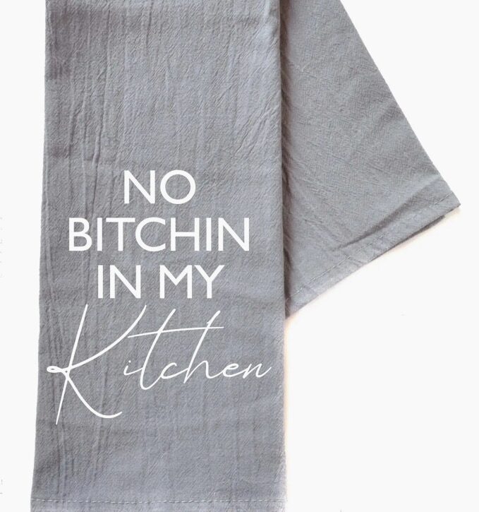 Gray kitchen towel with the phrase "No Bitchin in My Kitchen" printed in white text.