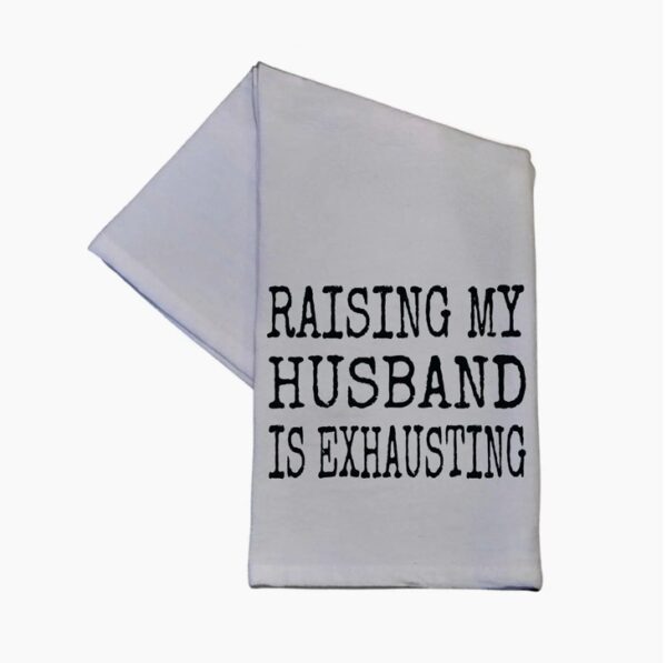 White kitchen towel with the text "Raising my husband is exhausting" printed in black.