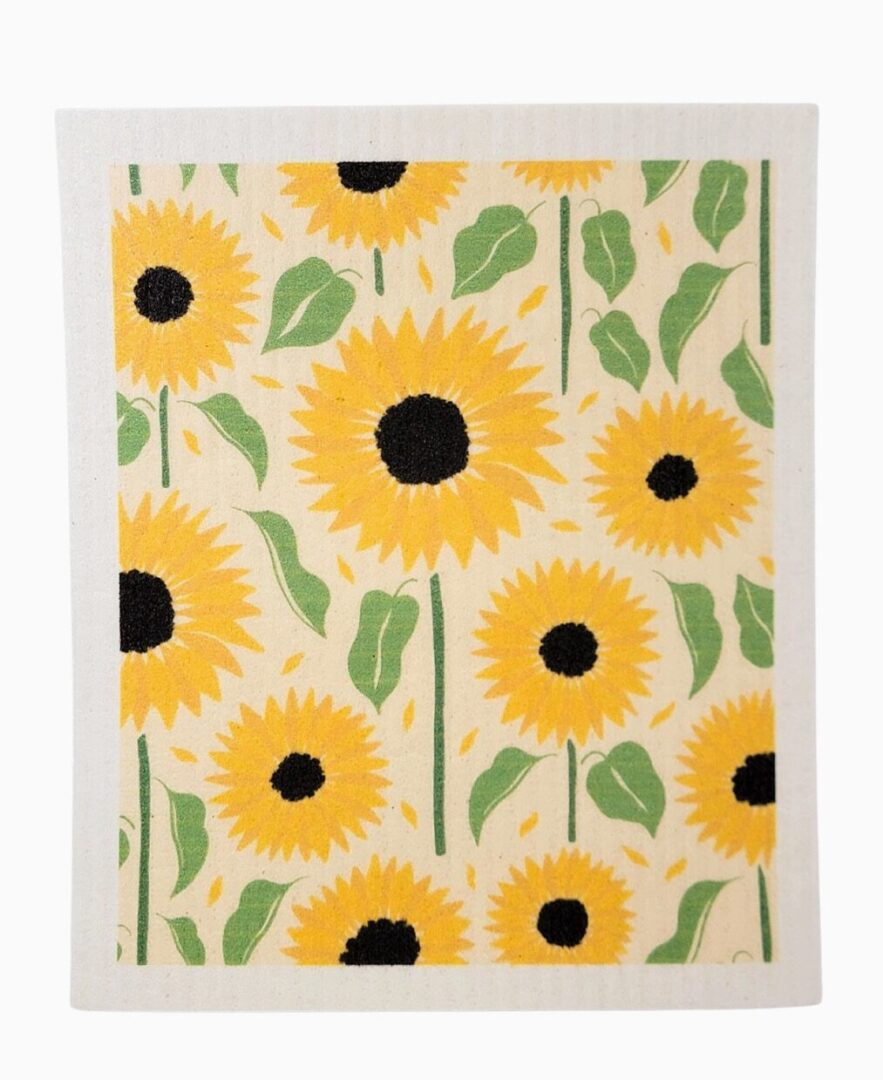 A patterned cloth with bright yellow sunflowers, black centers, and green leaves on a pale background.