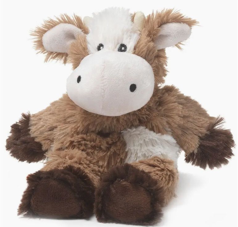 The Cow Warmie - Small is a plush cow toy featuring brown and white fur and small horns, shown sitting against a white background.