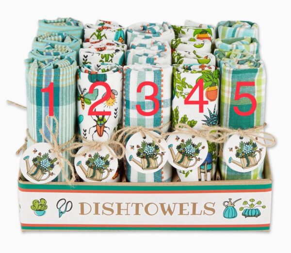 A display of Garden Shed Dish towels is arranged in a box. Each row features different patterns, including plaid and floral designs, numbered one to five, with decorative tags showcasing watering cans and plants.