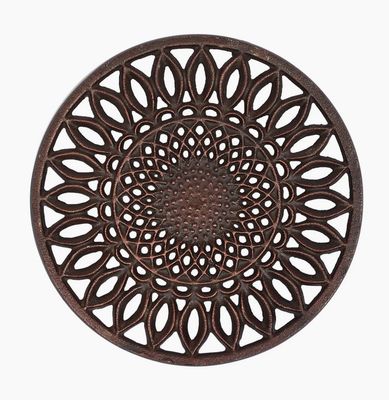 A sunflower-patterned cast iron trivet in dark brown on a plain white background.